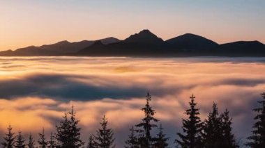 Colorful misty clouds motion fast in alpine mountains valley in peaceful sunset nature landscape. Time lapse, 4K, Panorama, Pan shot. 