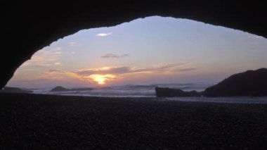 Beautiful sunset evening in Legzira Beach over huge rock arch with water waves in Morocco tourism area, Travel adventure background in peaceful nature Landscape.