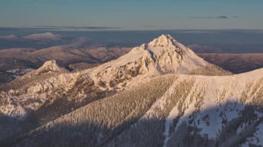 Donmuş Alp dağlarının zirvesinde gün batımının alacakaranlık vakti soğuk kış akşamında güzel doğa manzarasında. Zaman Çizelgesi, Uzaklaş, Sinematik Açık Hava Seyahat Görüntüsü 4K. 