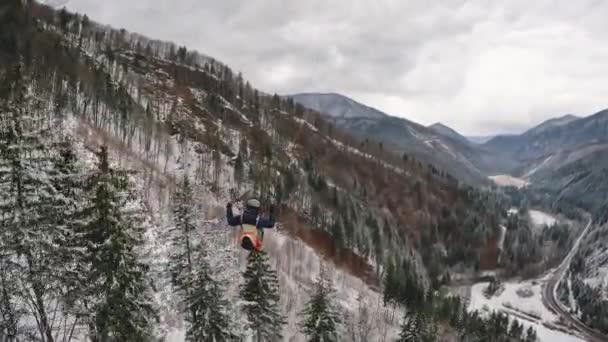 山の自然の中で冬の森林のストレスの上のパラグライダー飛行 自由飛行アドレナリン冒険フォローカム スローモーション60Fps — ストック動画