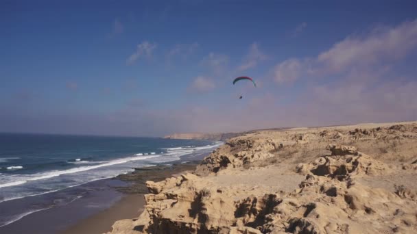 パラグライダーの自由 晴れた夏のモロッコの海の海岸でのフライトアドベンチャー アドレナリン極端なスポーツ — ストック動画