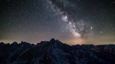 Sihirli Samanyolu Galaksisi yıldızları kışın Alp Dağları 'nda yıldızlı gökyüzünde hızla hareket eder. Zaman geçişi, panoramik çekim, gece gündüz.. 