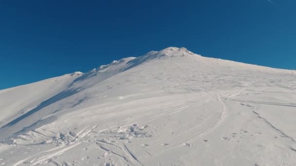 凍結した雪の山のピークから晴れた冬の自然の風景の中に青空に傾け コピースペースで 観光の冒険として理想的な背景 — ストック動画