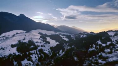 Kışın kırsal doğanın hava manzarası akşam dağlarında gün batımından sonra mavi gökyüzü, seyahat arka planı videosu 