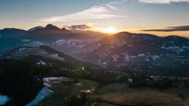 Hızlı bulutlarla dolu altın gün batımı ilkbahar başlarındaki dağlarda kırsal doğa üzerinde hareket ediyor. Hava görüntüsü Hiper Zaman Hızı, Zaman Hızı, Hiperlapse, 4K görüntü yükselt. 