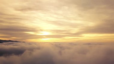 Cennetteki bulutların üzerinde uçan sihirli arka planda gün doğumunda sisli bulutlu gökyüzünün havadan görünüşü. Sinematik İHA çekim rahatlaması 