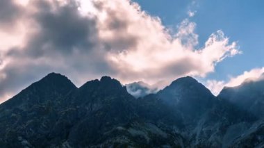 Güneş ışınlarının ve bulutların sihirli ışığı sisli Alp dağları üzerinde hızla hareket eder. Zaman aşımı, Pan 