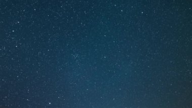 Mavi gece gökyüzünde uzayın barışçıl enerjisi. Yıldızlı zaman geçişlerinin karanlık arka planında milyonlarca yıldız var. 