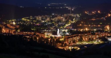 Kalabalık trafik ve sokak ışıklarıyla Avrupa 'nın küçük bir kasabasında hızlı bir gece hayatı. Gece Şehrinde Yolculuk Zamanaşımı, Yakınlaş 