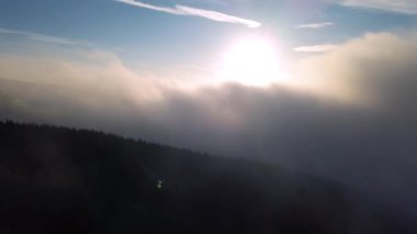 Güneşli doğa manzarasında sisli bulutların üzerinde sisli gökyüzü cenneti ile sihirli bir sabah güneşi doğuyor. Hava görüntüsü 4K İHA görüntüleri. 