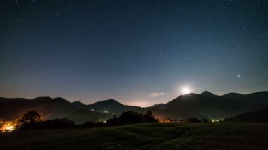 Yıldızlı gece gökyüzü hareketli yıldızlar ve ay dağların üzerinden yükseliyor kırsal alanda yaz sabahı şafağında. Astronomi Zaman aşımı, gece gündüz. 