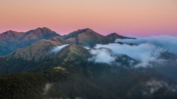 ニュージーランドの神秘的なアルプス山脈の上を移動霧雲でカラフルな日の出 自然の時間はズームアウト — ストック動画