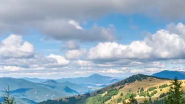 Güzel beyaz bulutlar çimenli dağların üzerinde hızlı hareket ediyor. Doğada güzel güneşli bir sonbahar günü. Zaman aşımı, aşağı eğ. 