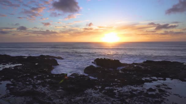 ニュージーランドの野生の風景の平和な夏の夕方にゆっくりとした動きの波と海岸上の夕日の黄金色 — ストック動画