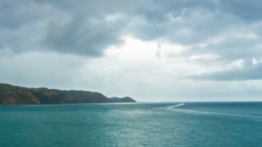 Yeni Zelanda 'da yaz yağmurlu bir günde, okyanus kıyısının mavi sularında bir teknede yelken açmak. Zaman aşımı, Steadicam Hiper sapma. 
