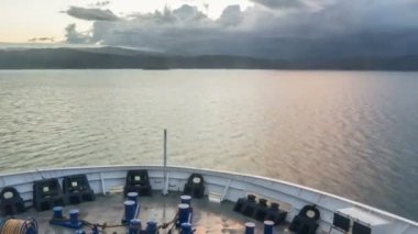 Kargo gemisinde yolculuk. Fırtınalı bulutlarla dolu karanlık bir sabahta limandan mavi suya gitmek. Kabin görünümlü zaman aşımı, Steadicam, Hyperlapse. 