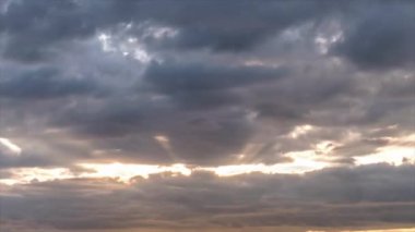 Gökyüzü bulutlarının renkli arkaplanı ve gün batımında hızla hareket eden güneş ışığı. Zaman aşımı, Zaman aşımı. 