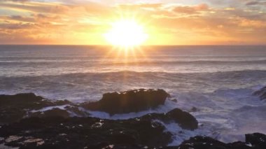 Kayalık okyanus kıyısında renkli gündoğumu gökyüzü ve Yeni Zelanda 'da huzurlu bir yaz sabahı dalgaları.. 