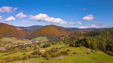 Güzel güneşli bir günde, kırsal alanda sonbaharın hava hızında düşüşü. Renkli ağaçların ve çayırların üzerinden uç. Zaman aşımı 4k video arkaplanı