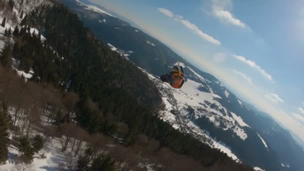 冬の山々でパラグライダーに乗って 自由フリーフライトのアドレナリン冒険はアクションカムに従います カムに従ってください スタディカムショット — ストック動画