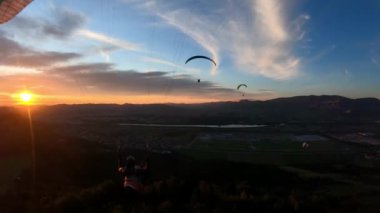 Gün batımında arkadaşlarla huzurlu bir akşam yamaç paraşütü uçuşu. Özgürlük adrenalin sporu. Kamerayı izle. 