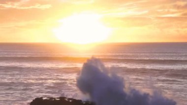Yeni Zelanda 'da okyanus kıyısı sularının üzerinde altın gün doğumu. Pan, Panoramik, Ağır çekim. 