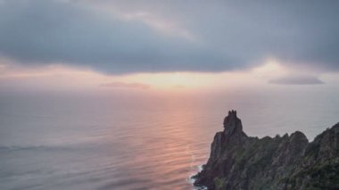 Okyanus kıyısında gün doğumunun güzel renkleriyle huzurlu bir sabah ve yaz mevsiminde Yeni Zelanda 'da kayalık dağlar. Zaman aşımı, yakınlaş, Panoramik, Pan. 