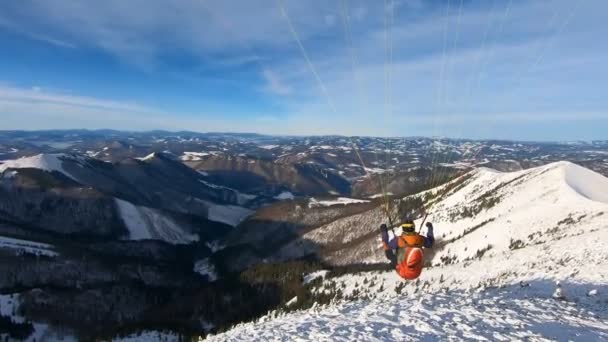 美しい晴れた日の冬のアルプスの山の上の平和なパラグライダーフライト アドレナリンスポーツアドベンチャー カムをフォローする Steadycam ショット — ストック動画
