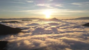 Güneşli bir sabah doğasında cennet gibi dağlarda hızla hareket eden sisli bulutlu dalgalarla Peaceful Sunrise 'ın son sürat uçuşu. Zaman aşımı. 