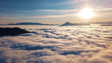 Yavaş çekim. Bulutların üstünde güneş doğar. Güzel renklerde yaz doğası. Altın sabahta hava manzarası 