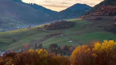 Kırsal kesimin güzel sonbahar renkleri güneşli akşam günbatımında küçük köy vadisinde hızla hareket eden sisli bulutlarla birlikte. Zaman aşımı, yakınlaştır. 