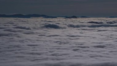 Mavi bulutların üzerindeki huzurlu manzara, gün batımından önce sisli dağ vadisinde hızla hareket ediyor.. 