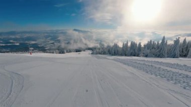 Güneşli kış mevsiminde güzel bir günde kapalı olan boş kayak merkezi orman doğası üzerinde sisli bulutlarla kaplı. Açık hava macera arka planı 