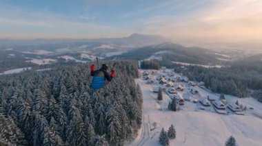 Paraglider kış alplerinin üzerinde uçar sihirli bir şekilde donmuş sabah doğasında altın gündoğumunda, yamaç paraşütü kamerasını takip eder, Adrenalin macerası özgürce uçar. 
