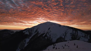 Kışın Alp Dağları 'ndaki sihirli kanlı bulutların havadan görünüşü altın sabah doğasında renkli gündoğumunda. Açık hava macera arka planı.