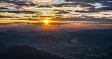 Güneşin rengarenk ışığı ve altın bulutlarla güzel bir günbatımı. Yaz dağlarında gökyüzü. Avrupa 'da kırsal bir akşam.. 