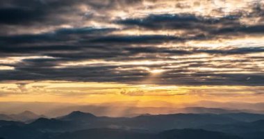 Yaz sabahında güneşin doğuşunun güzel renkleri. Avrupa 'da dağların üzerinde hareket eden güneş ve bulutların altın ışıklarıyla. Zaman aşımı panoraması