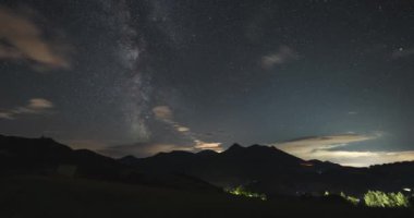 Samanyolu galaksisi ile renkli gece gökyüzü, yıldızlar ve bulutlar yazın dağlarda hızla hareket ediyorlar. Zaman aşımı, gece gündüz.