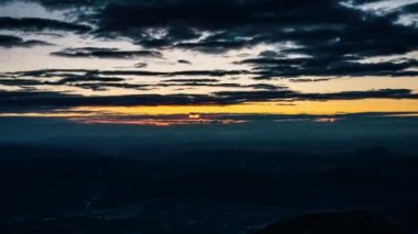 Güneşin doğuşunun güzel renkleri, güneş ve bulutlar Avrupa 'da güneşli bir yaz sabahında dağların üzerinden hızla geçiyor. Zaman aşımı, yakınlaştır.