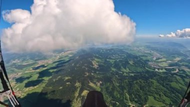 Yüksek Paragliding uçuş macerası bulutlar üzerinde gökyüzü yeşil kırsal alanda güneşli bahar doğasında. Uçan özgürlük adrenalin macerası, birinci şahıs bakış açısı.
