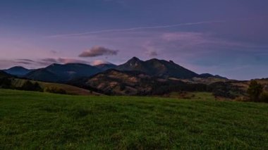 Yeşil alp dağlarında hızlı hareket eden bulutlarla altın gün doğumu güzel yaz sabahı manzarası zaman akıp gidiyor.