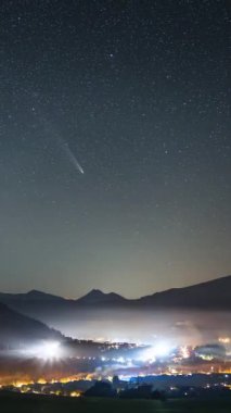 Kuyrukluyıldız Tsuchinshan Atlas ve Samanyolu Galaksisi 'nin yıldızlarının kırsal bölgede hızla hareket ettiği dikey bir video. Yoğun trafik yolculuğu alanı, Yıldızlar Astronomi Zaman geçişi arkaplanı