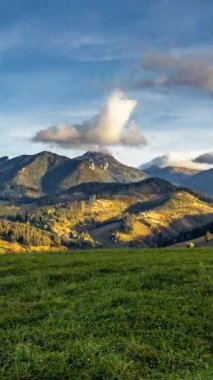 Bulutlar Alp Dağları 'nın üzerinden hızla geçiyor doğa altın günbatımında, dikey video, zaman atlaması, barışçıl arka plan sosyal medya hikayesi için ideal..