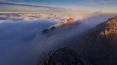 Beautiful view from top of misty rocky peak in Alps mountains nature above foggy clouds at sunrise, dreamy heaven landscape, Outdoor adventure background.