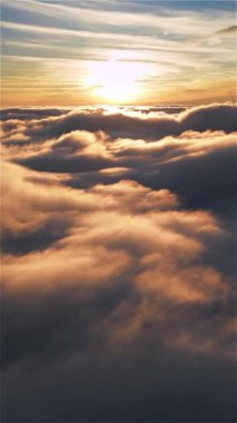 Sonbahar sisli doğa manzarasında sihirli gündoğumunda rüya gibi bulutların üzerinde uçmanın dikey videosu. Açık hava macera arka planının hava görüntüsü, sosyal medya hikayesi için ideal.