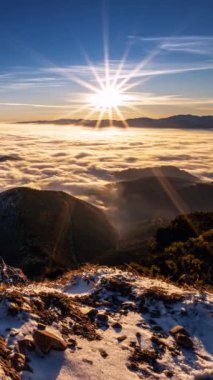 Alp Dağları 'nda huzur içinde hareket eden sisli bulutların üzerinde altın gün doğumunun dikey videosu zaman atlaması. Sihirli doğa açık hava macerası için ideal sosyal medya hikayesi.