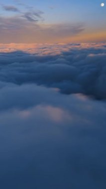 Bulutların üzerinde uçan rüya gibi bir manzara. Gökyüzü gökyüzü büyülü bir sabah ve mavi saatte dolunay var. Sosyal medya hikayesi için açık hava macera özgürlüğü görüşü.