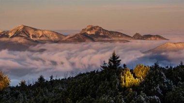 Donmuş dağların panoraması sisli bulutlar vadideki bir nehir gibi akar sisli bir sabah doğasında altın gündoğumunda