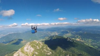 Yeşil alp dağlarının üzerinde yükselen termal paraglitler, adrenalin dolu macera uçuşları. Hava görüntüsü, aksiyon kamerası, bahar doğasının panoraması. Bir kuş gibi özgür.