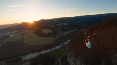 Altın gün batımında güneşli bahar doğasının üzerinde huzurlu bir uçuş. Özgürlük adrenalin macerası, bedava uçuş, kamera takip.